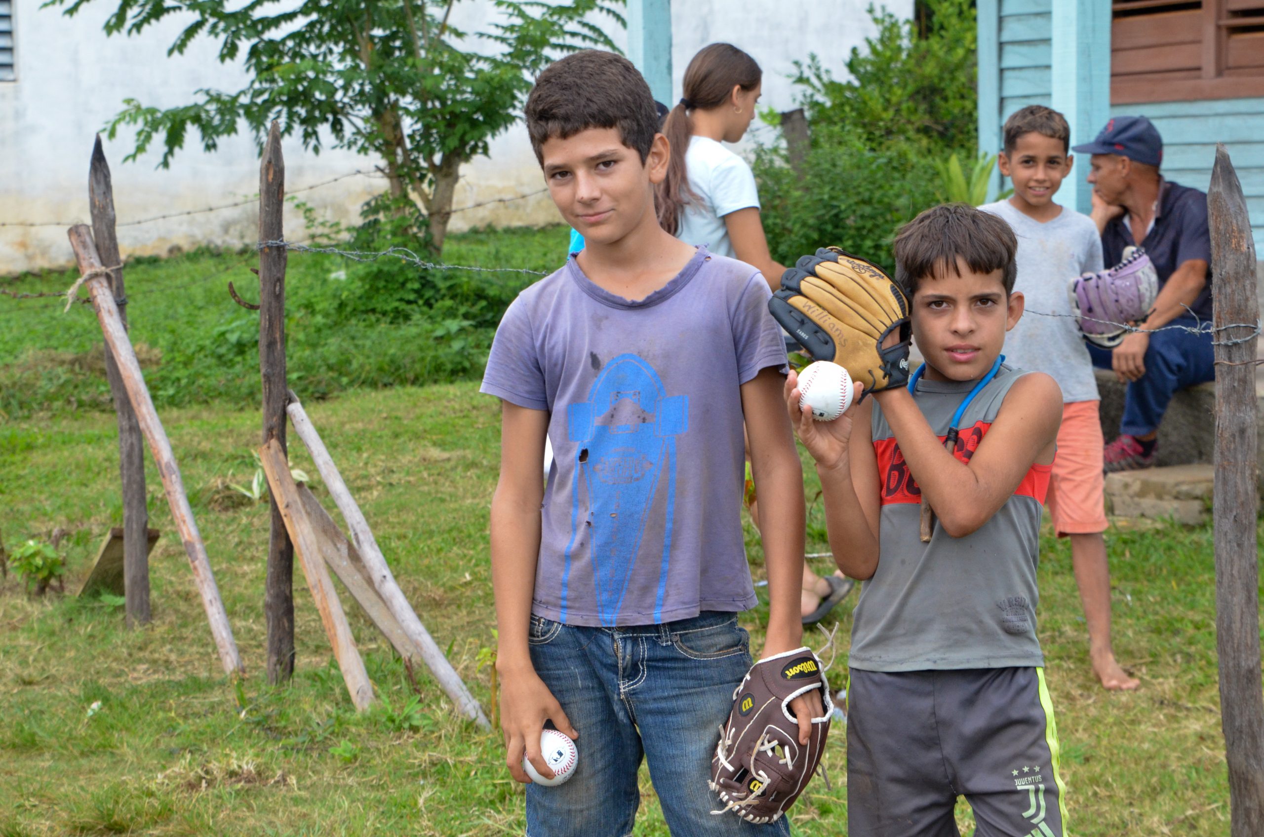 Two Cuban Children holding baseball equipment donations.