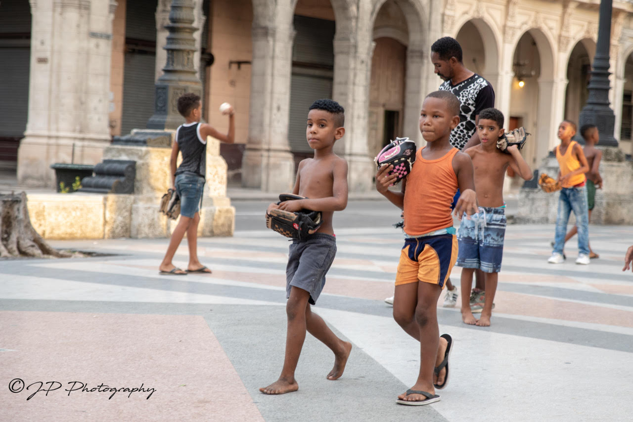 Cuban children playing with their baseball glove donations.